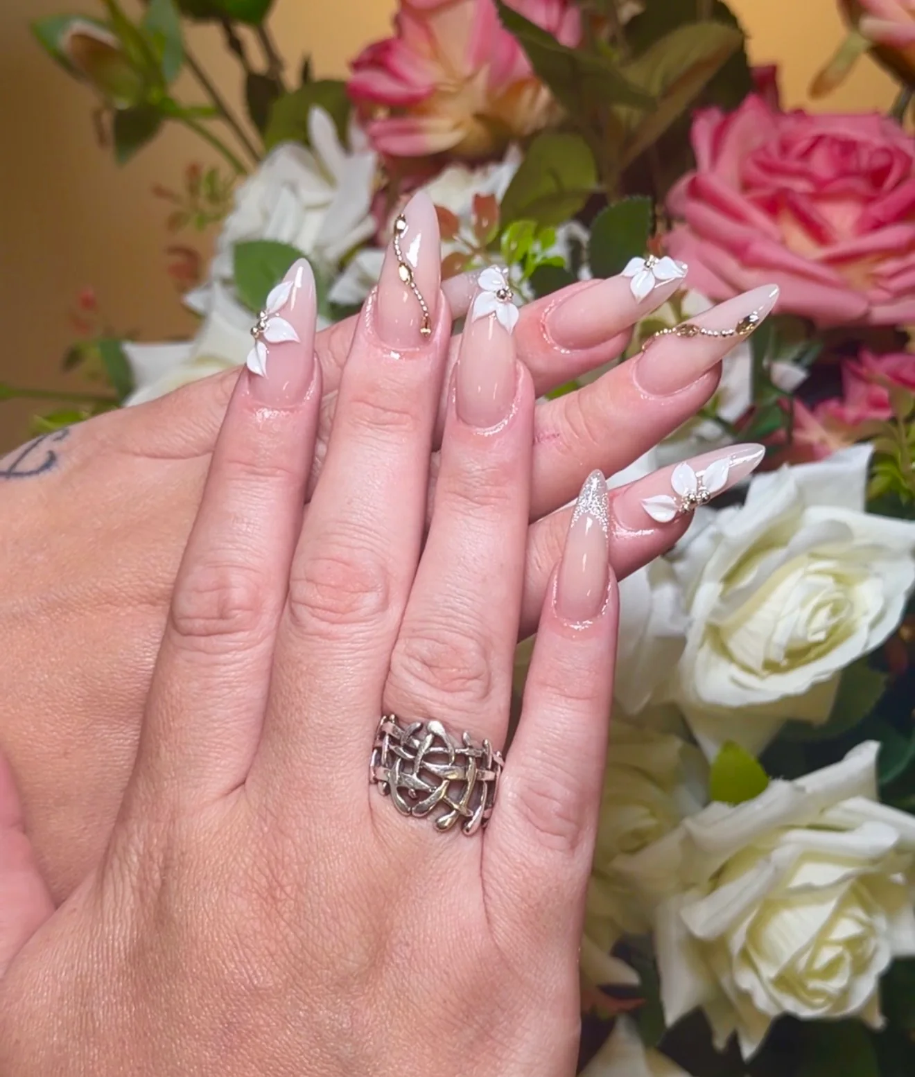 Pink sculpted nails with delicate white floral details