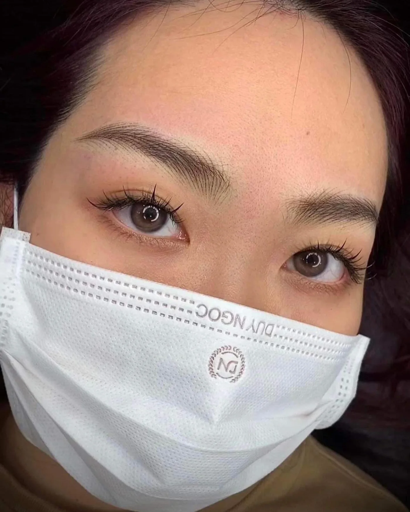 Client with softly shaped permanent brows