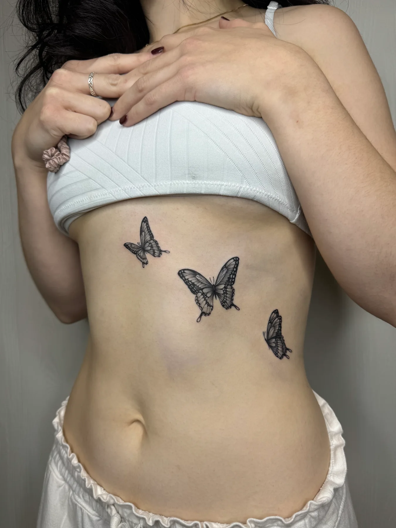 Minimal butterfly tattoos on a client's side