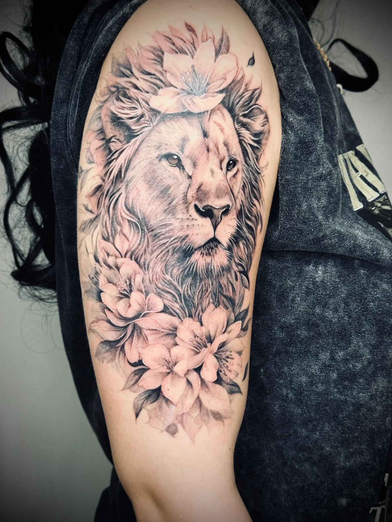 Black and grey lion and floral tattoo